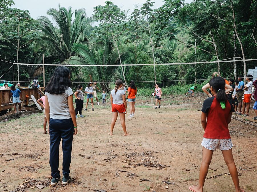 Campers playing volleyball under the palms