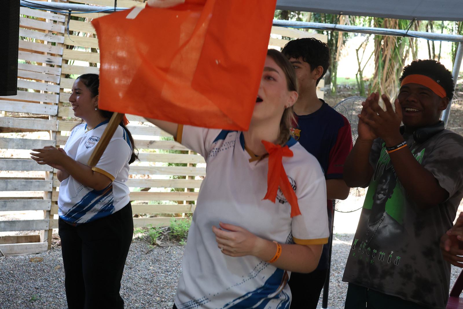Team leaders waving a flag and cheering campers on during a game