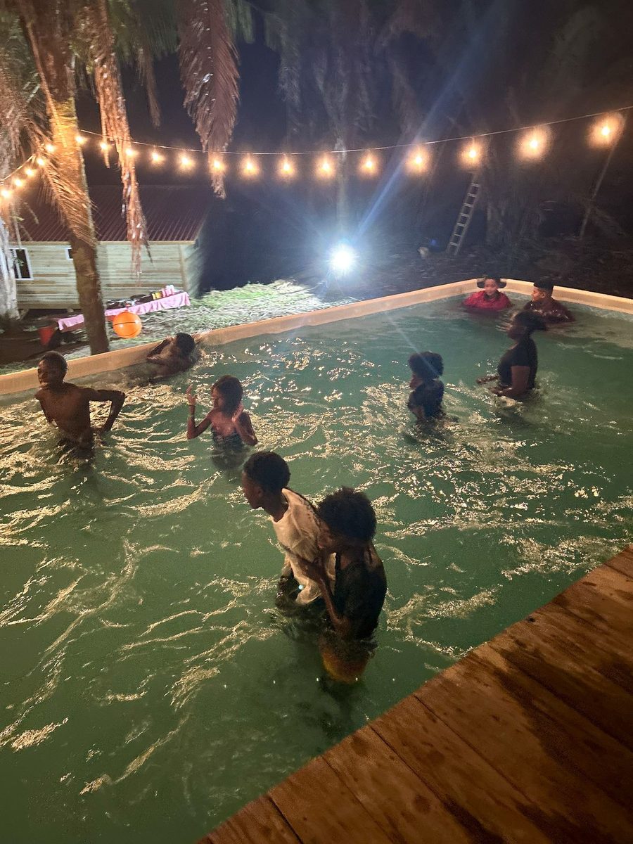 The pool lit up under string lights at night