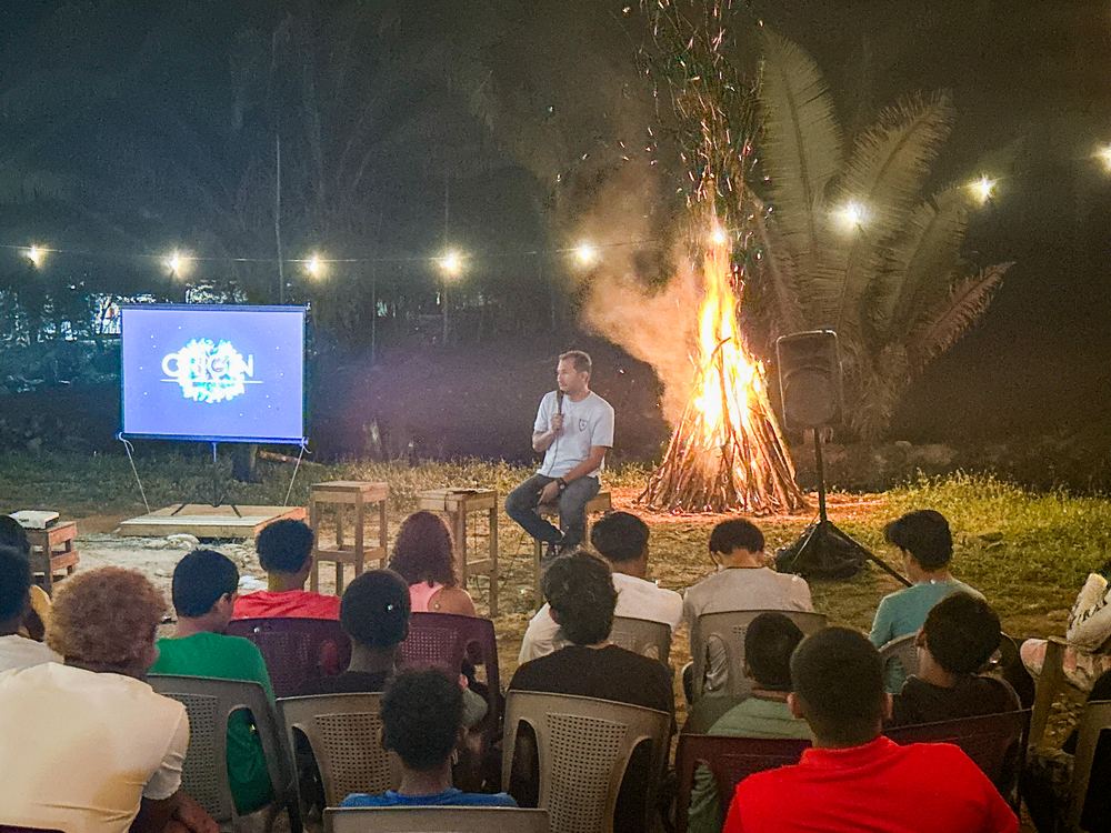 Night service outdoors with a bonfire and screen